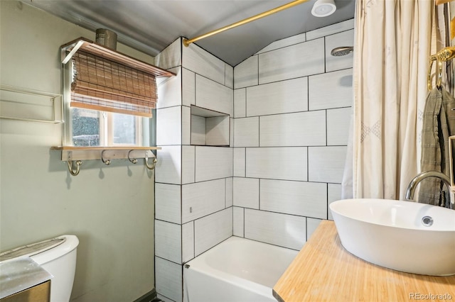 full bathroom featuring lofted ceiling, toilet, shower / bath combo with shower curtain, and sink