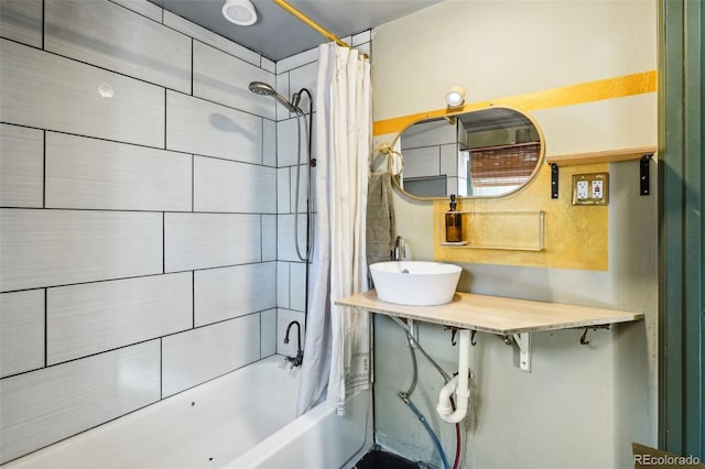 bathroom with shower / bathtub combination with curtain and sink