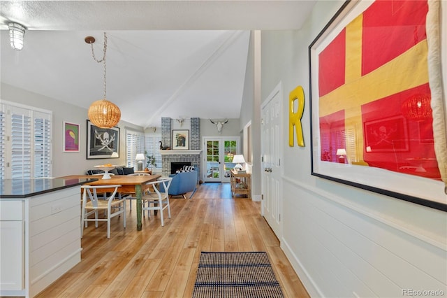13 Pinyon Pine Rd, Littleton, CO 80127 - dining room featuring a fireplace, light wood-style flooring, and vaulted ceiling