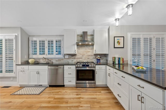 13 Pinyon Pine Rd, Littleton, CO 80127 - kitchen with stainless steel appliances, wall chimney exhaust hood, dark countertops, and a sink