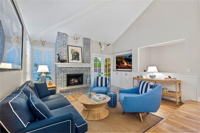 13 Pinyon Pine Rd, Littleton, CO 80127 - living room with high vaulted ceiling, wood finished floors, a brick fireplace, beamed ceiling, and a wainscoted wall