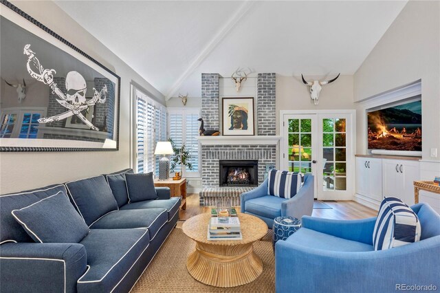 13 Pinyon Pine Rd, Littleton, CO 80127 - living room featuring wood finished floors, a fireplace, beam ceiling, and high vaulted ceiling