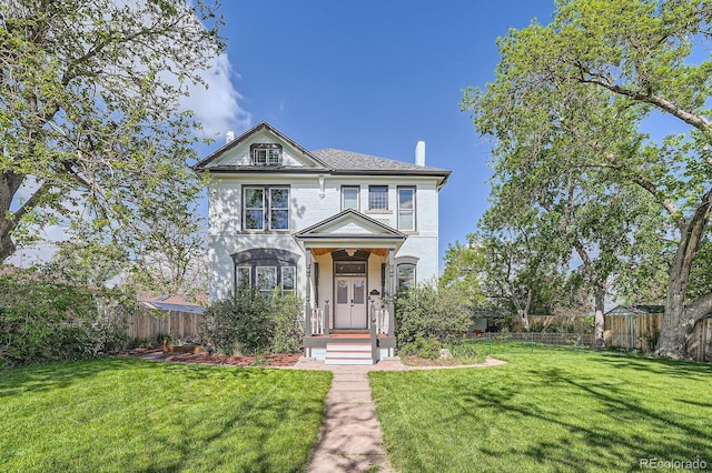 victorian house featuring a front lawn and fence