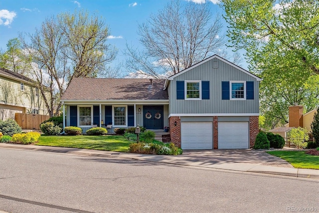 tri-level home with brick siding, driveway, and a garage