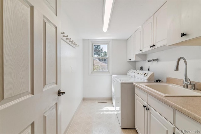 laundry room with cabinet space, washer and dryer, and baseboards