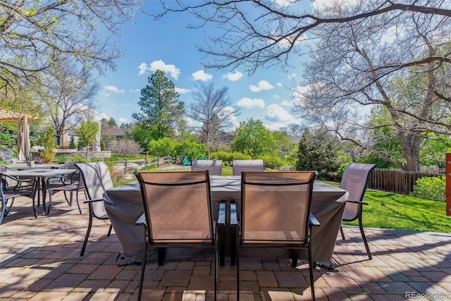 view of patio featuring outdoor dining space and fence
