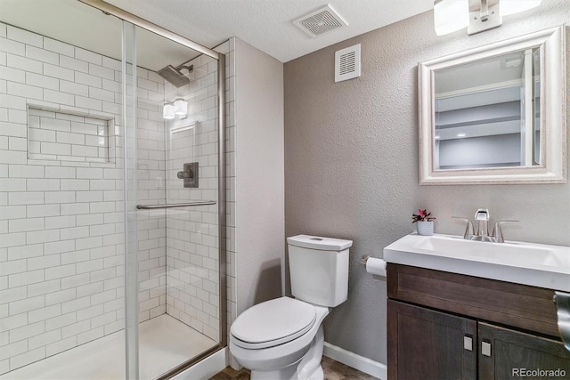 bathroom featuring toilet, a shower stall, and vanity
