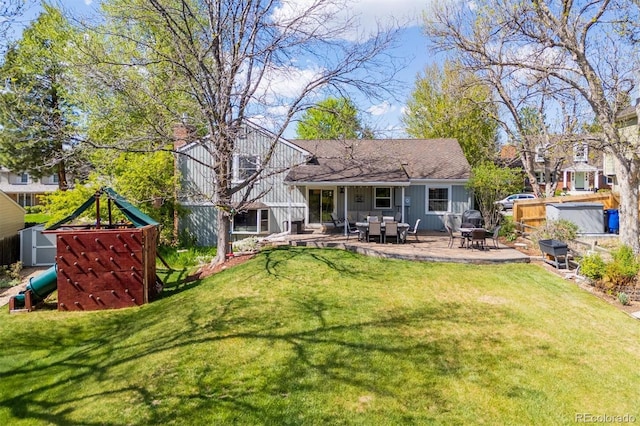 rear view of property featuring a patio area, a lawn, and a shed