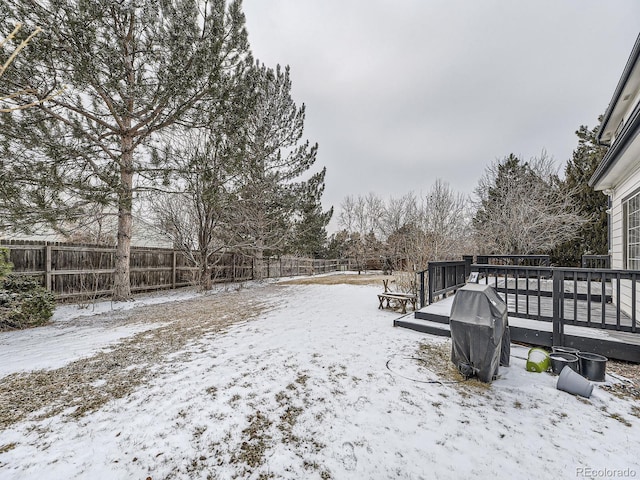 yard covered in snow with a wooden deck