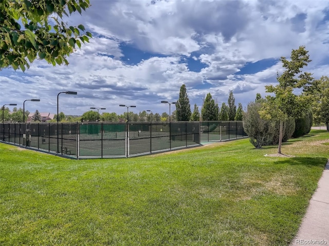 view of tennis court with a lawn