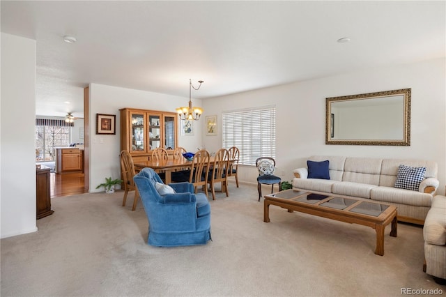 living room with a notable chandelier, a wealth of natural light, and light colored carpet