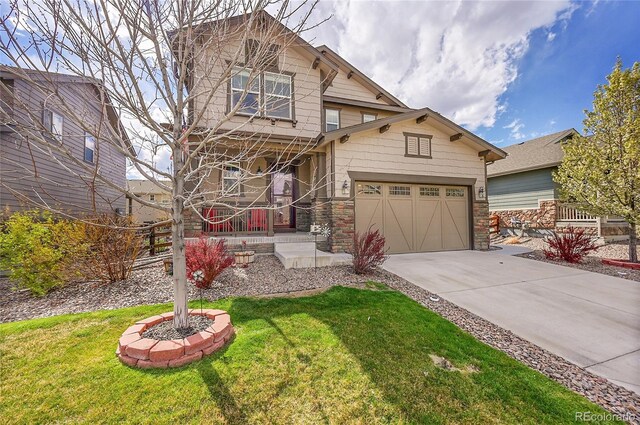 craftsman-style home with a porch, a front lawn, driveway, and stone siding