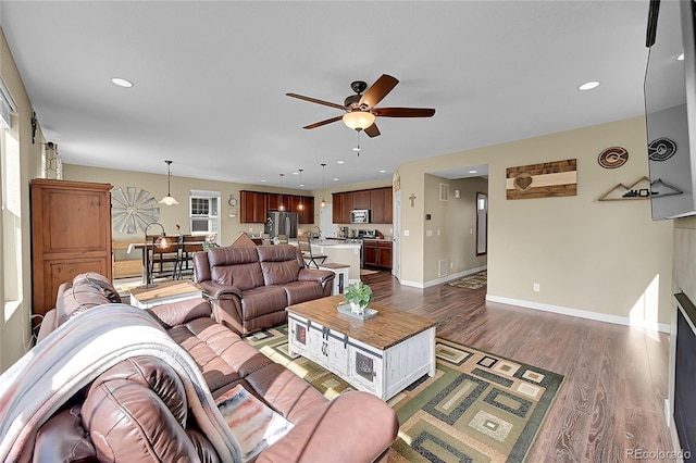 living room featuring ceiling fan, a wealth of natural light, baseboards, dark wood-style floors, and recessed lighting