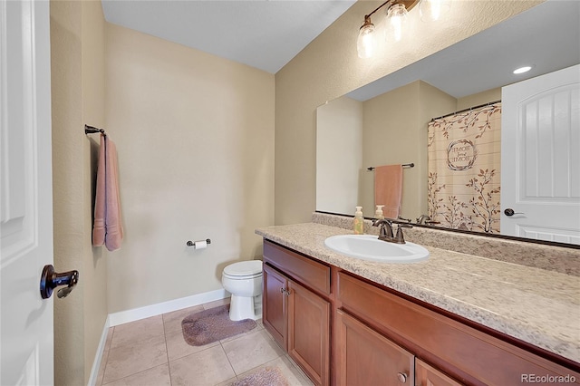 bathroom featuring tile patterned flooring, baseboards, toilet, and vanity