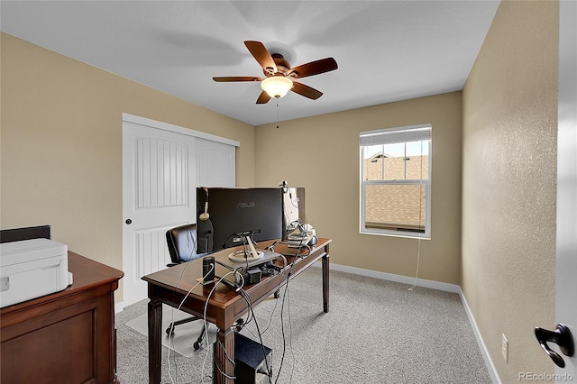 office space featuring ceiling fan, baseboards, and light carpet