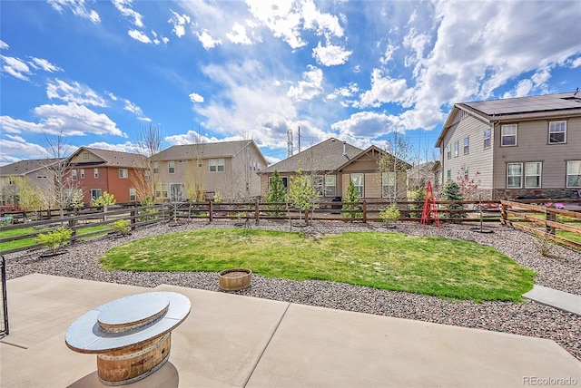 view of yard featuring a patio area, a fenced backyard, and a residential view