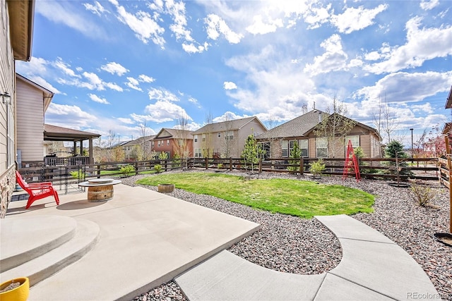 view of yard with a fenced backyard, a patio area, an outdoor fire pit, and a residential view