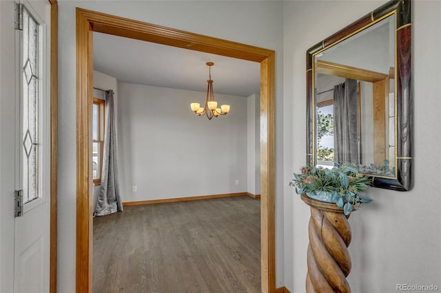 hallway featuring hardwood / wood-style floors and a chandelier