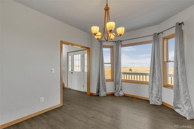 unfurnished room featuring a notable chandelier and dark hardwood / wood-style flooring