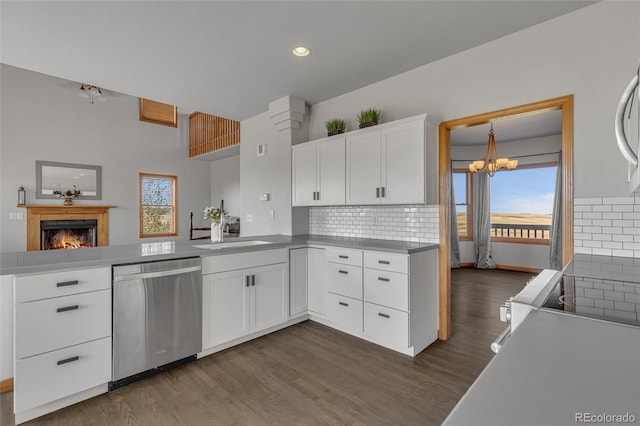 kitchen featuring white cabinets, dishwasher, dark wood-type flooring, and kitchen peninsula