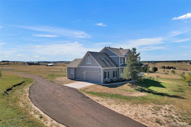 view of front facade with a front yard and a rural view