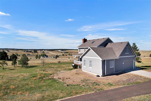 6696 Sunset Cir, Kiowa, CO 80117 - view of side of home featuring a garage, driveway, a shingled roof, and a chimney