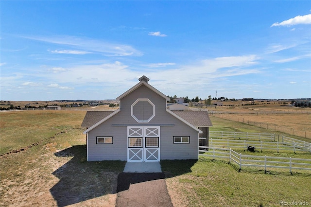 view of outbuilding with a rural view and a yard