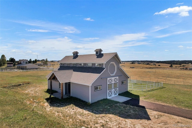 view of side of home featuring a rural view and a yard