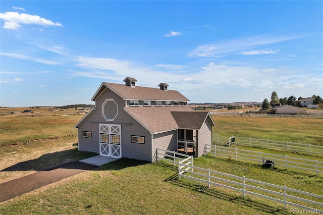 view of front facade featuring a rural view and an outbuilding