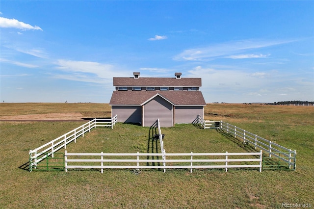 view of side of property featuring a rural view and a yard