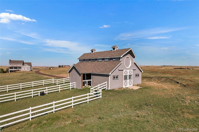 view of front of home featuring an outbuilding, a rural view, and a front lawn