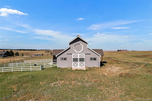 view of outdoor structure with a rural view and a lawn