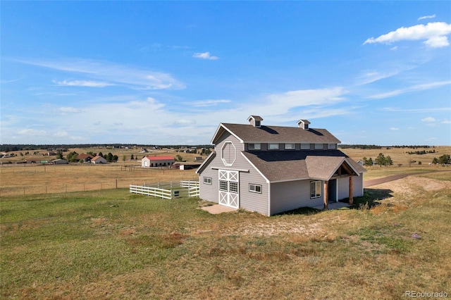 view of property exterior with a rural view and a yard