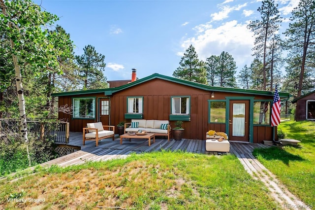 5818 S Skyline Dr, Evergreen, CO 80439 - rear view of house with board and batten siding, an outdoor hangout area, a deck, and a yard