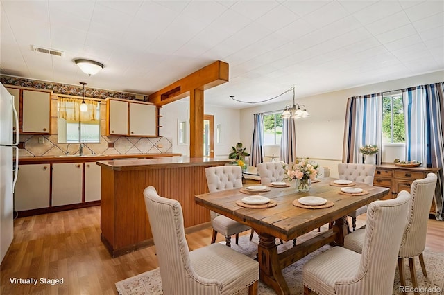 5818 S Skyline Dr, Evergreen, CO 80439 - dining space featuring plenty of natural light, light wood-style flooring, and a chandelier