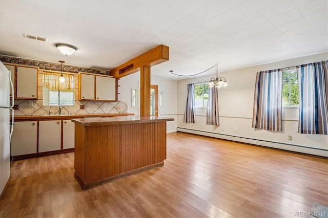 5818 S Skyline Dr, Evergreen, CO 80439 - kitchen with healthy amount of natural light, baseboard heating, light wood-style flooring, and decorative light fixtures