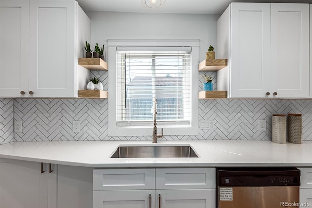 kitchen with sink, dishwasher, white cabinets, and decorative backsplash