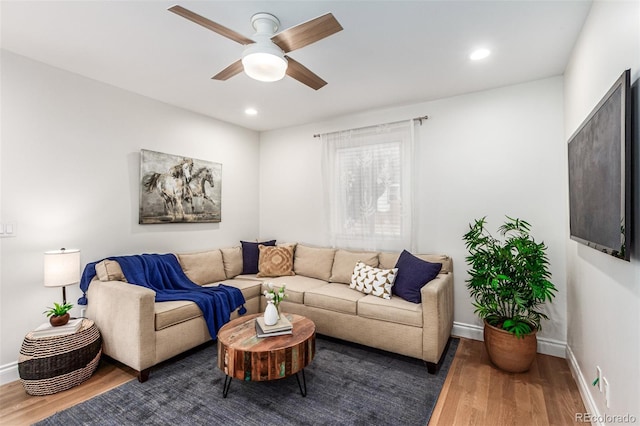 living room featuring dark wood-type flooring and ceiling fan