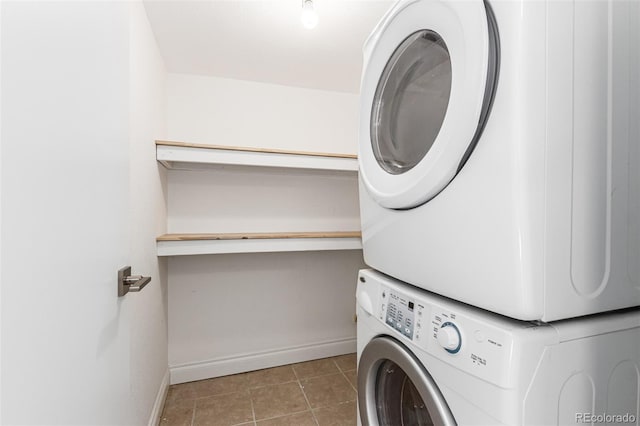 laundry area featuring stacked washer and clothes dryer and light tile patterned floors