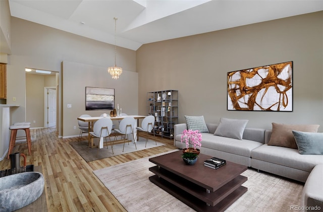 1343 Villa Grv, Monument, CO 80132 - living area featuring high vaulted ceiling, a chandelier, light wood finished floors, and baseboards