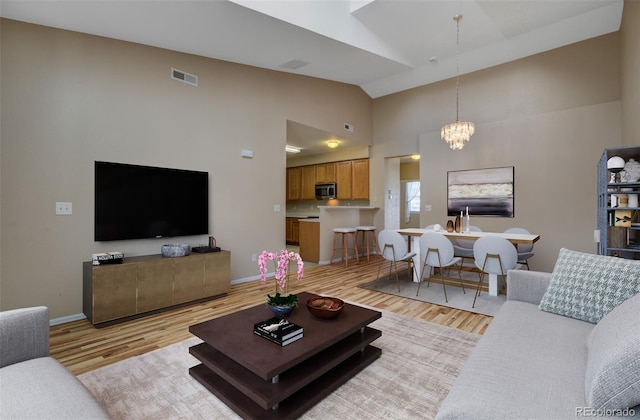 1343 Villa Grv, Monument, CO 80132 - living room with light wood-style floors, a chandelier, high vaulted ceiling, and baseboards