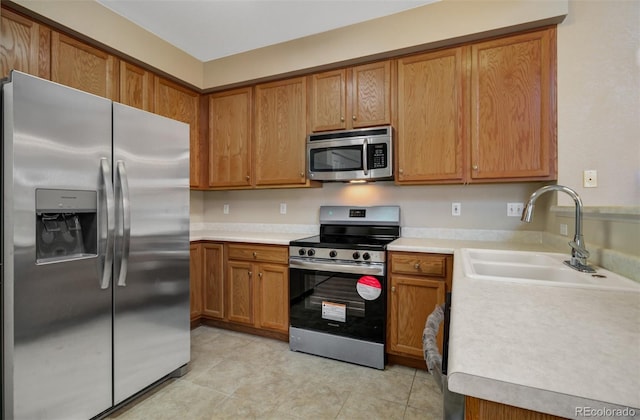 1343 Villa Grv, Monument, CO 80132 - kitchen featuring appliances with stainless steel finishes, a sink, light countertops, and brown cabinets