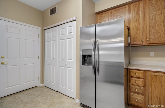 1343 Villa Grv, Monument, CO 80132 - kitchen with stainless steel fridge with ice dispenser, brown cabinetry, and light countertops