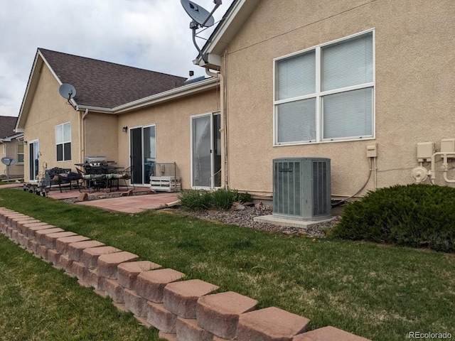 1343 Villa Grv, Monument, CO 80132 - rear view of house featuring cooling unit, a patio area, stucco siding, and a yard