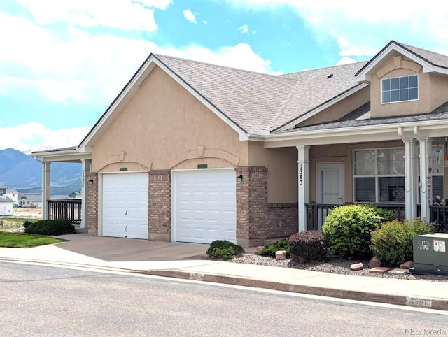 1343 Villa Grv, Monument, CO 80132 - view of front of home featuring concrete driveway, a shingled roof, a garage, brick siding, and stucco siding
