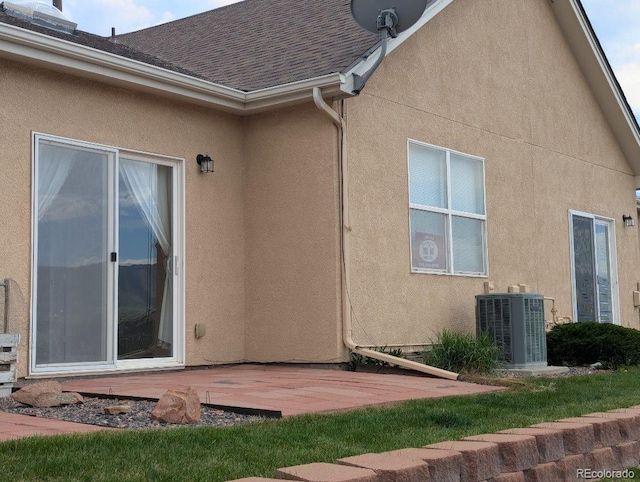 1343 Villa Grv, Monument, CO 80132 - rear view of house with central air condition unit, stucco siding, a patio, and a shingled roof