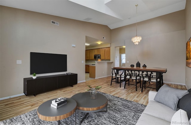 1343 Villa Grv, Monument, CO 80132 - living room featuring light wood-style floors, high vaulted ceiling, and a chandelier