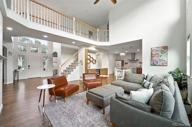 5731 S Yampa St, Centennial, CO 80015 - living area featuring a high ceiling, stairway, a ceiling fan, dark wood-style floors, and plenty of natural light