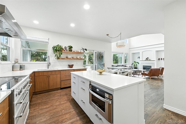 5731 S Yampa St, Centennial, CO 80015 - kitchen featuring wall chimney exhaust hood, high end stove, brown cabinets, light countertops, and recessed lighting