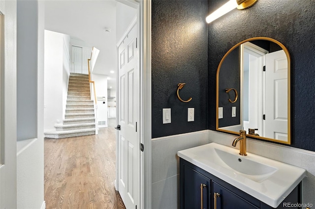 5731 S Yampa St, Centennial, CO 80015 - bathroom with vanity, wood finished floors, a textured wall, and wainscoting